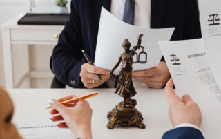 A lawyers desk with a small statue of justice holding a sword and scales.