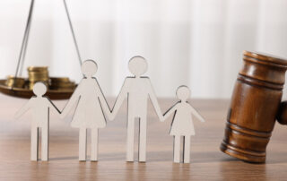 Paper cut outs of a family with a gavel and scale nearby.